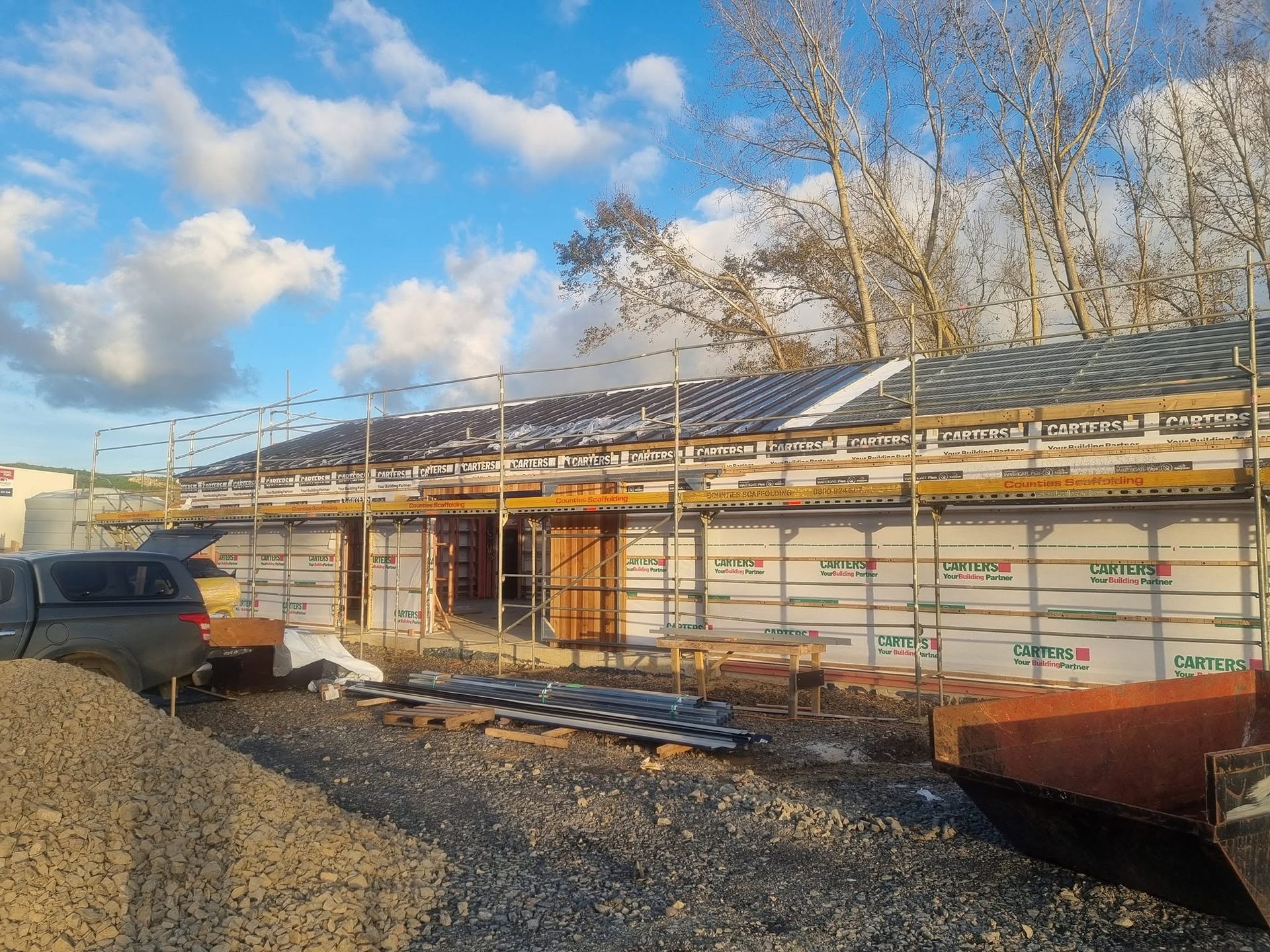 Scaffolded roof re-clad in progress under blue sky
