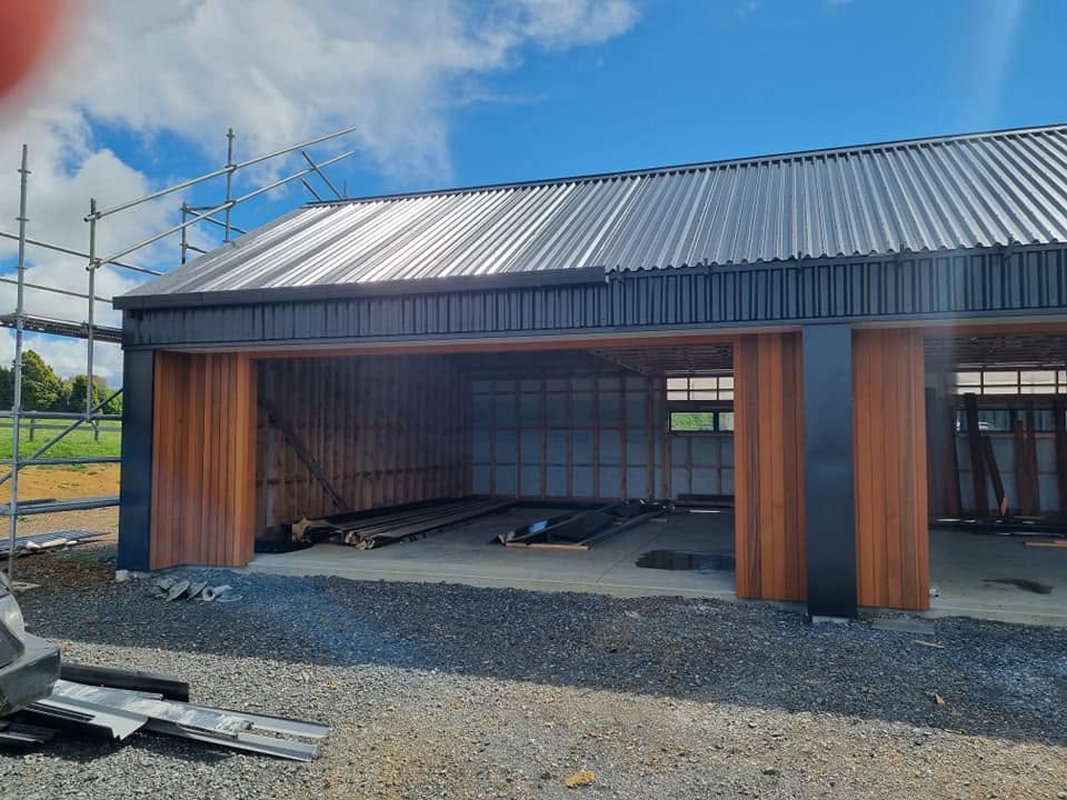 Long run metal roof on a timber-clad workshop